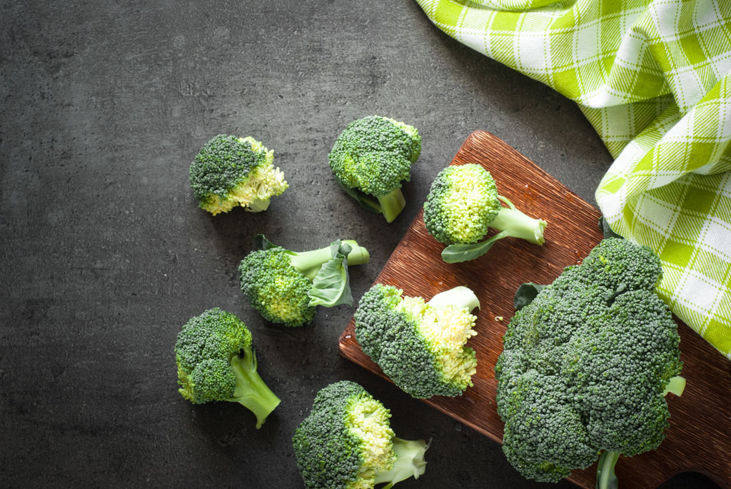 Fresh broccoli at dark table. Top view with copy space. Green food.