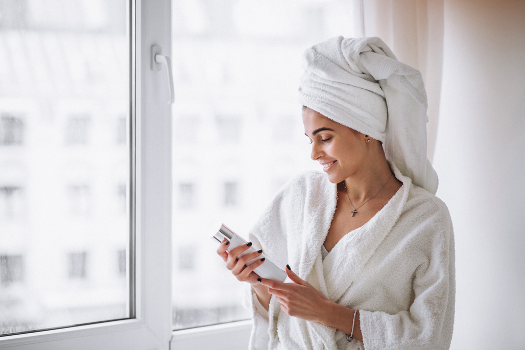 Woman standing by the window in bathrobe